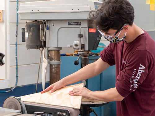 Student using the jigsaw machine at the Carpentry Shop